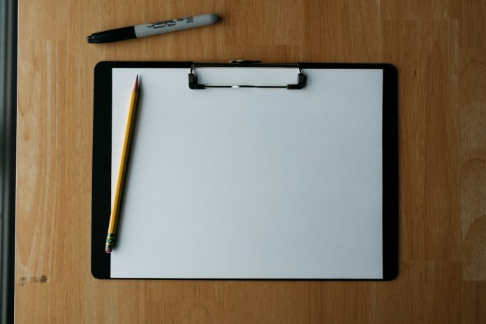 Clipboard and pen A clipboard with a pencil and pen resting on it