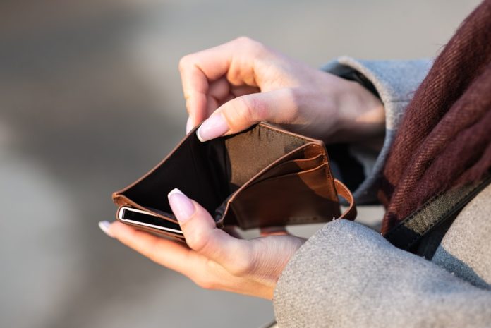 Empty wallet and phone Hands holding an empty wallet and a phone