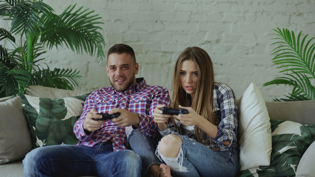 A couple playing console games together on a couch