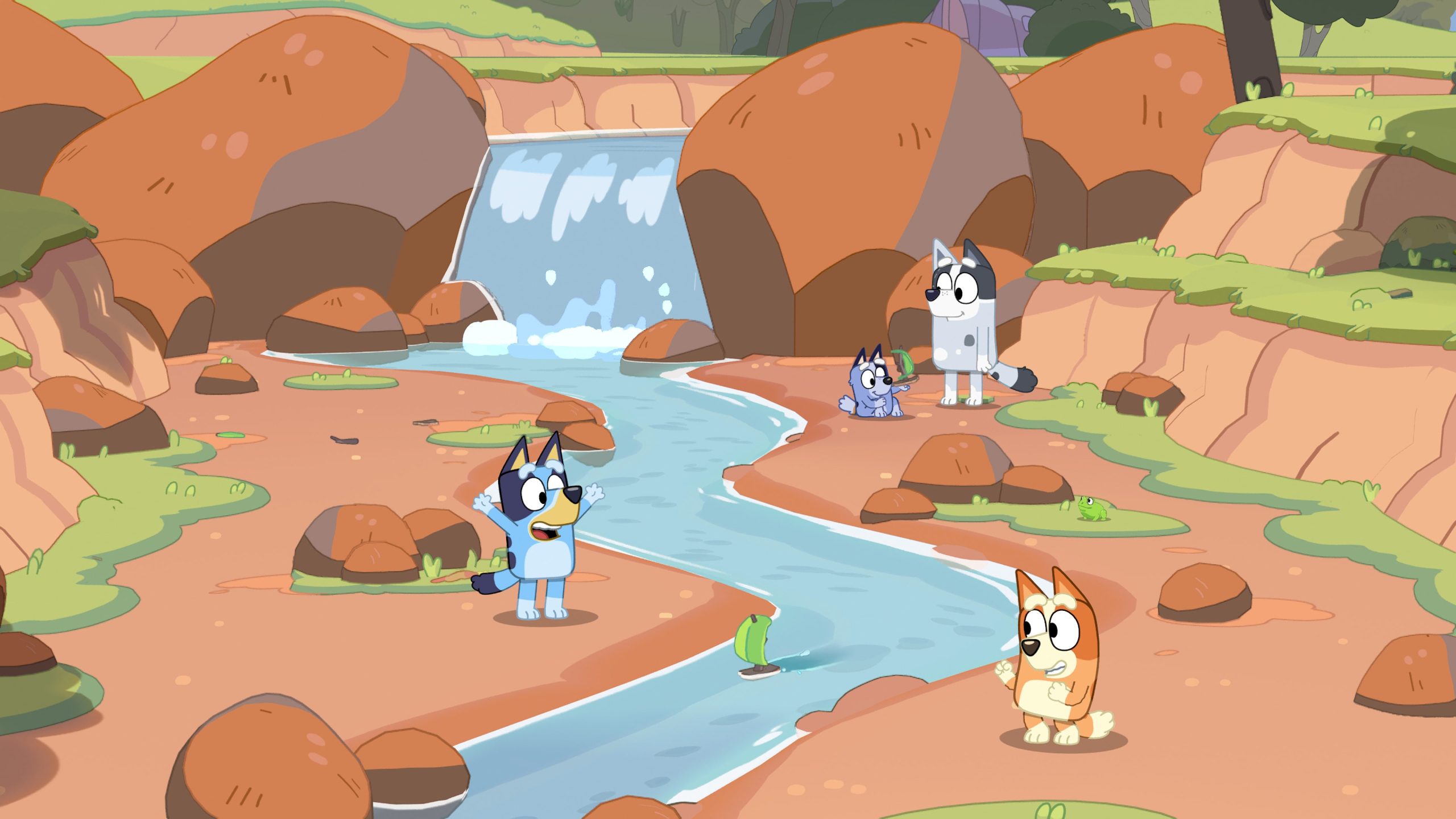 Bluey and Bingo explore a rocky creek with a small waterfall in Bluey's Happy Snaps