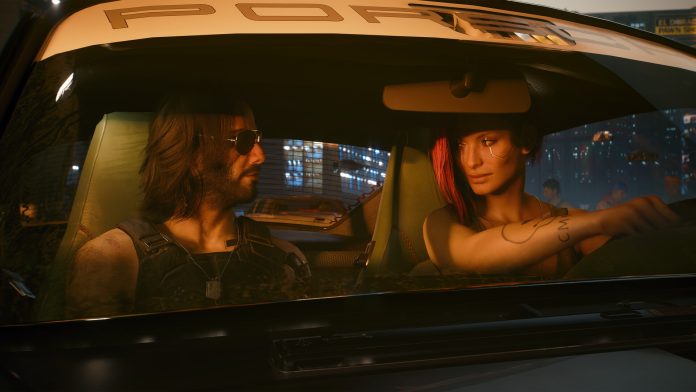 A man in sunglasses and a woman with red hair sit in the front of a car at night in Night City