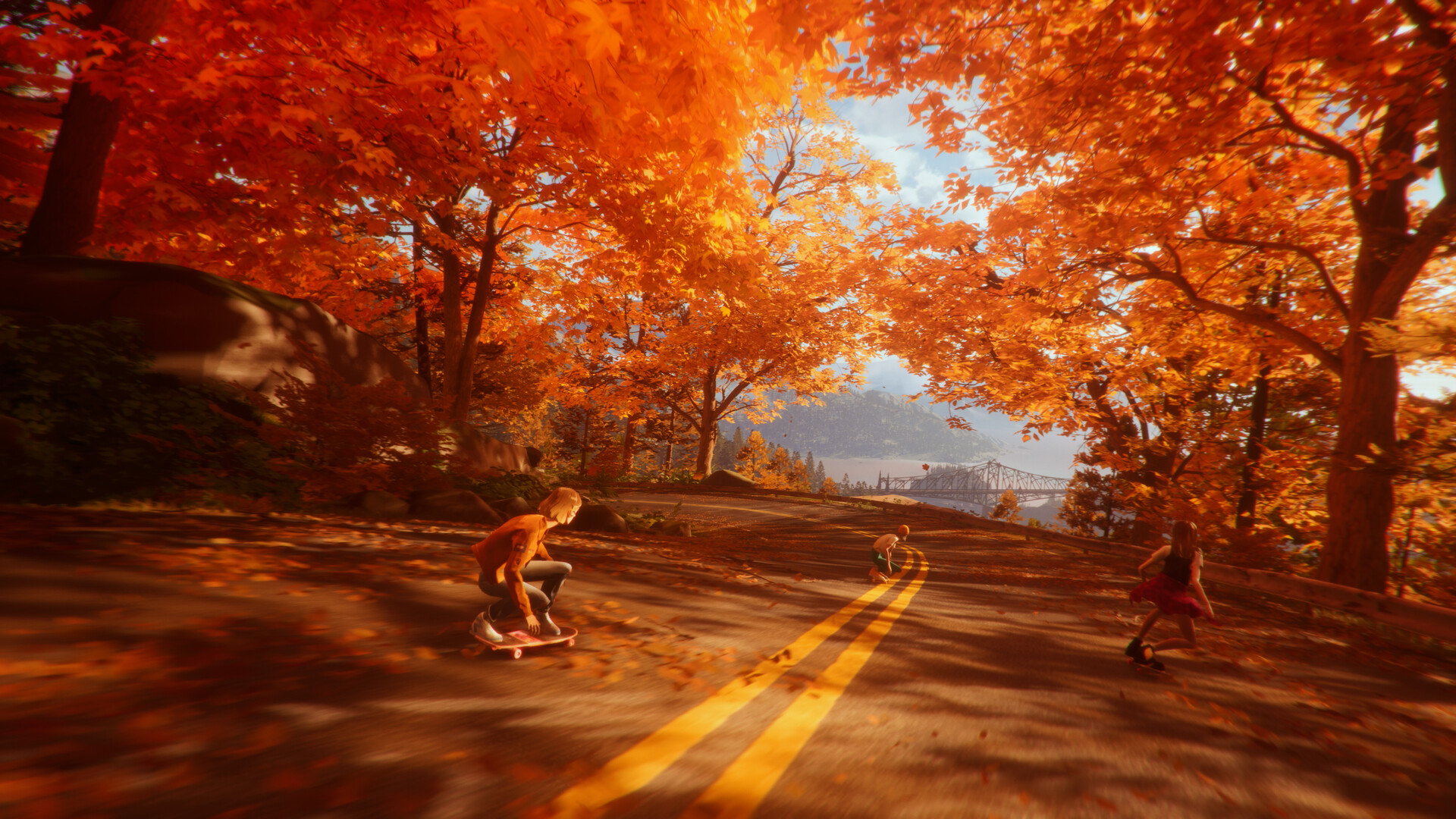 Three teenagers skateboard down a road lined with orange autumn trees