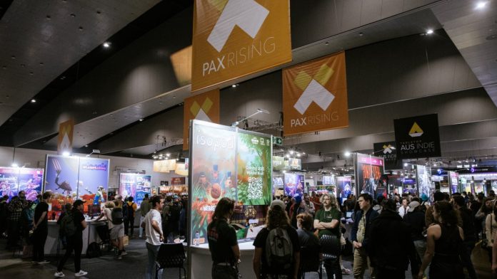 PAX Rising at PAX Aus. Photo Maria Boyadgis PAX Aus A crowded PAX Rising area under hanging PAX Rising banners, with rows of indie game booths
