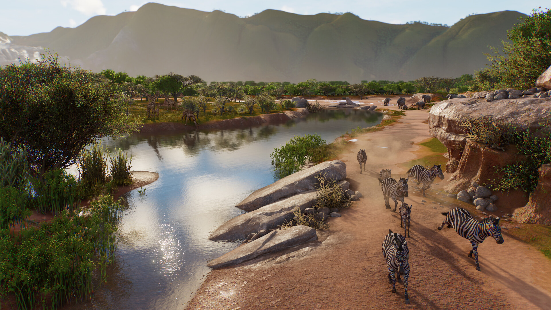 Zebras walking along a river bank beneath distant mountains in Planet Zoo 2.