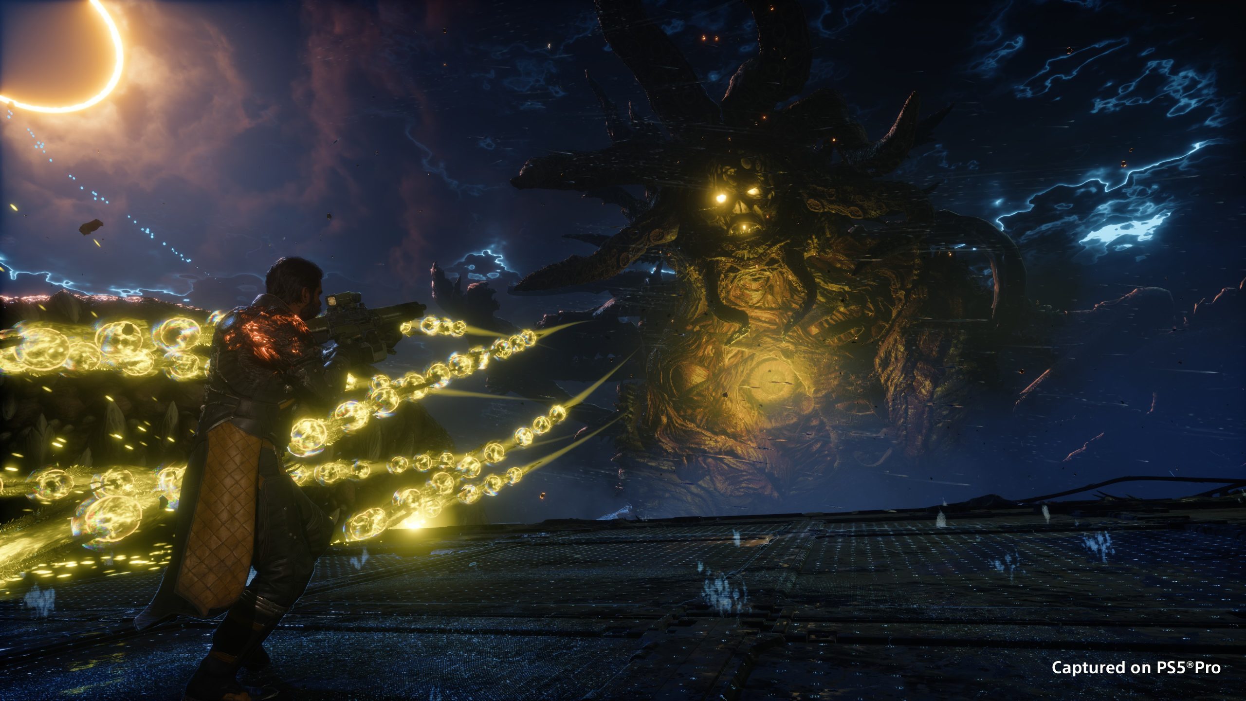 A character fires streams of glowing yellow orbs at a huge tentacle-headed boss under a dark stormy sky, captured on PS5 Pro.