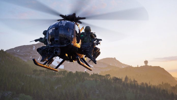 A small military helicopter carrying soldiers on its skids flies low over forested hills at dusk